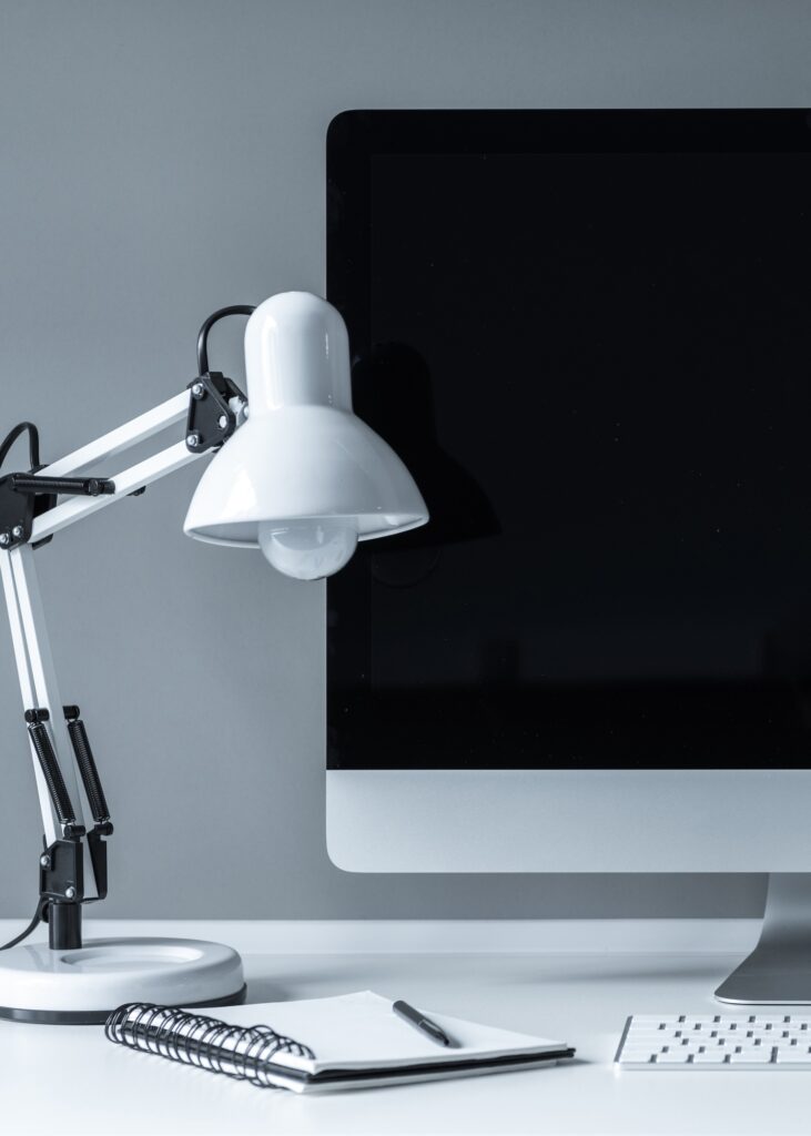 white table lamp and computer with black screen